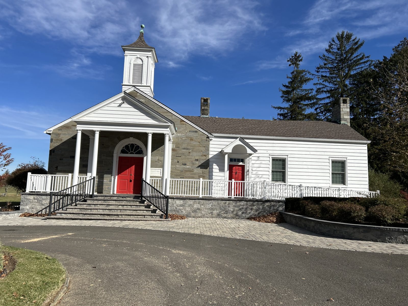 The chapel at Whitemarsh Memorial Park, a white building with red doors and a steeple